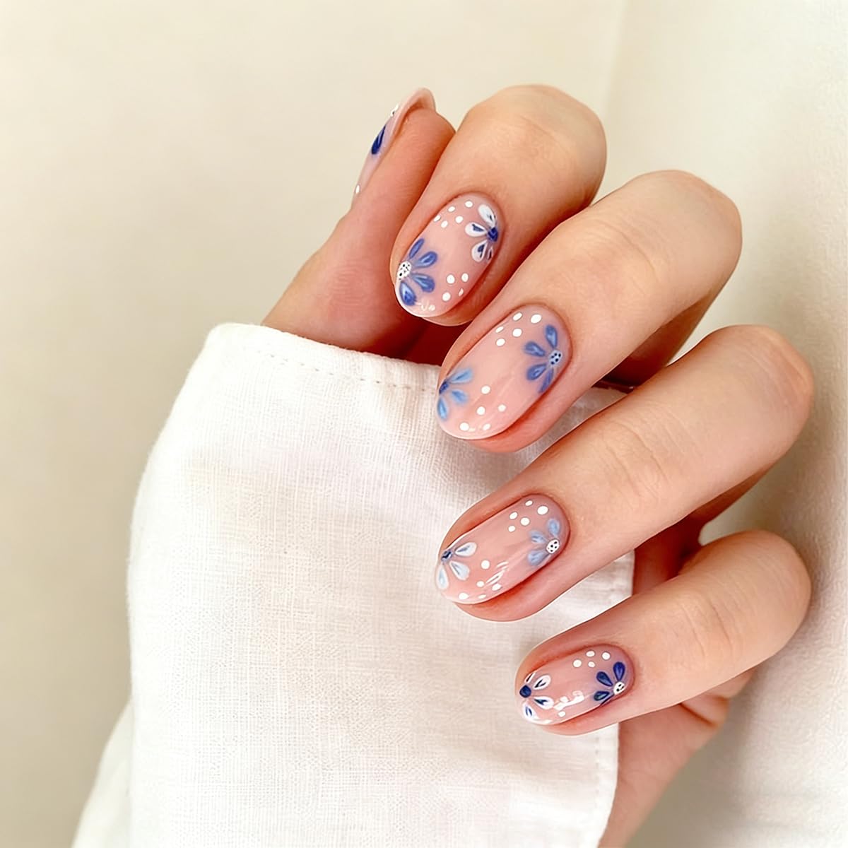 short oval press on nails with nude base blue floral and polka dot design short oval press on nails with nude base blue floral and polka dot design