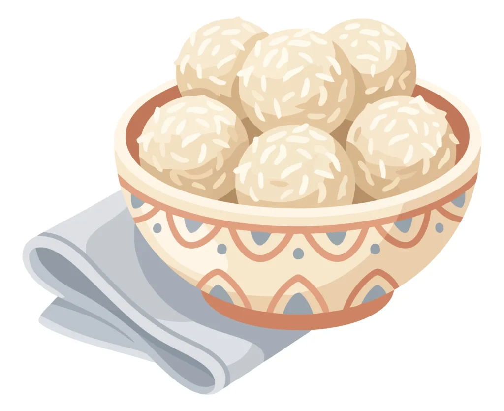 bowl of traditional rice balls or coconut laddoo dessert, a sweet snack served in a decorative ceramic bowl on a folded cloth napkin