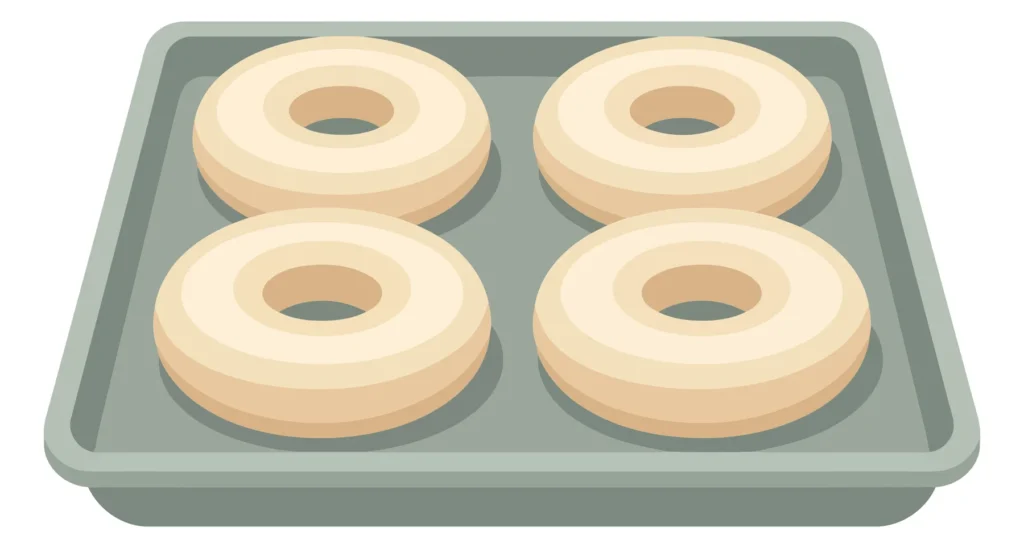 Four Raw Dough Donuts Arranged On A Rectangular Metal Baking Sheet, Topdown View Of Uncooked Pastry Rings Ready For The Oven, Isolated Vecto four raw dough donuts arranged on a rectangular metal baking sheet, topdown view of uncooked pastry rings ready for the oven, isolated vecto