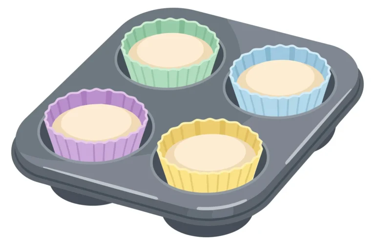 muffin tin with colorful silicone baking cups filled with raw batter isolated on white background