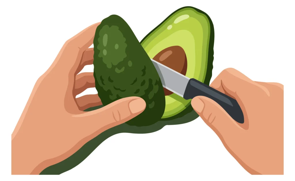 A hand cutting an avocado in half with a knife, showing the green flesh inside.