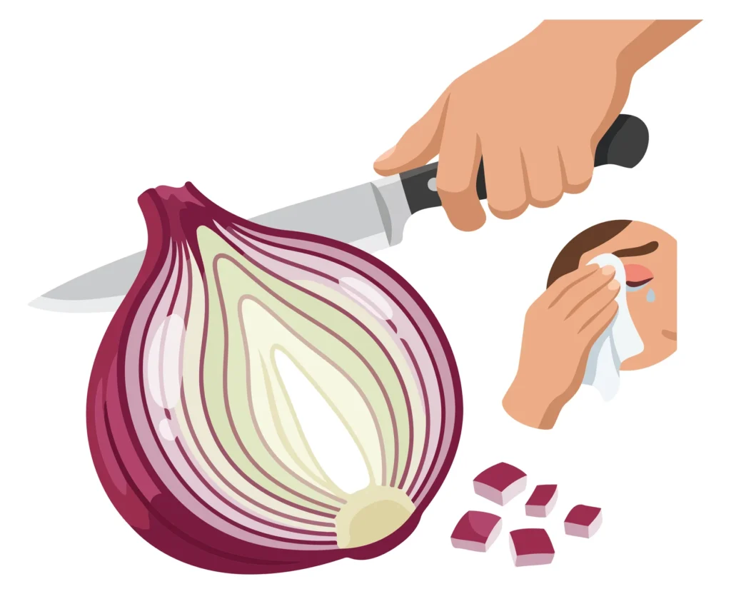 A hand cutting an onion on a cutting board with peeled onion pieces and a hand wiping the knife blade.