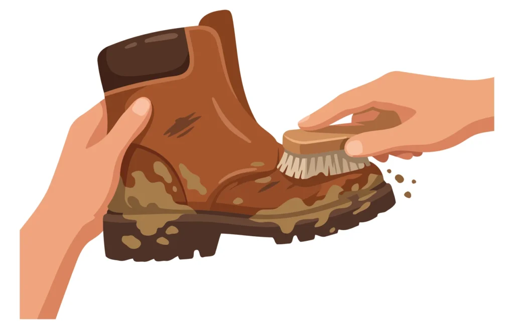 Hand cleaning camouflage hiking boot with toothbrush A hand brushing a camouflage hiking boot with a toothbrush in an illustration.