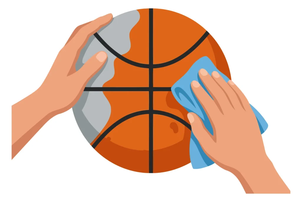 Hand cleaning a basketball with a cloth Two hands cleaning a basketball with a cloth